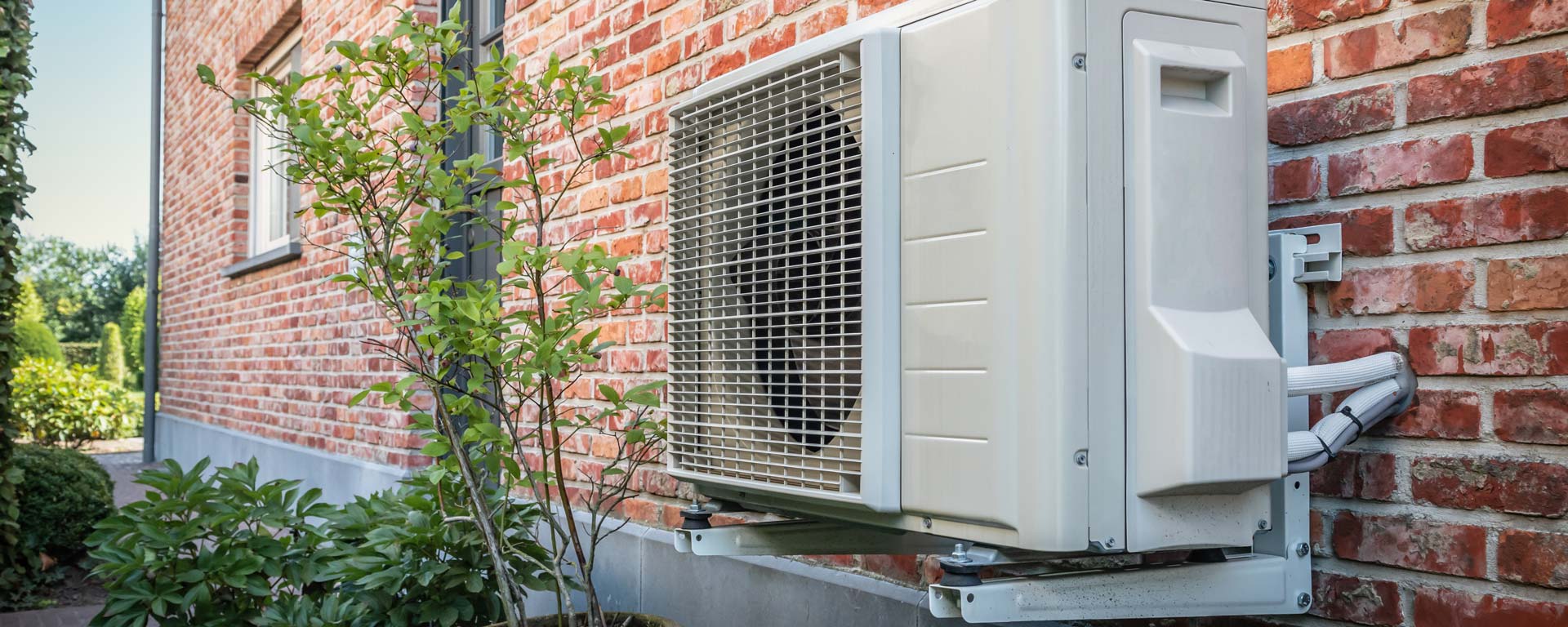 electric heat pump mounted to home exterior wall