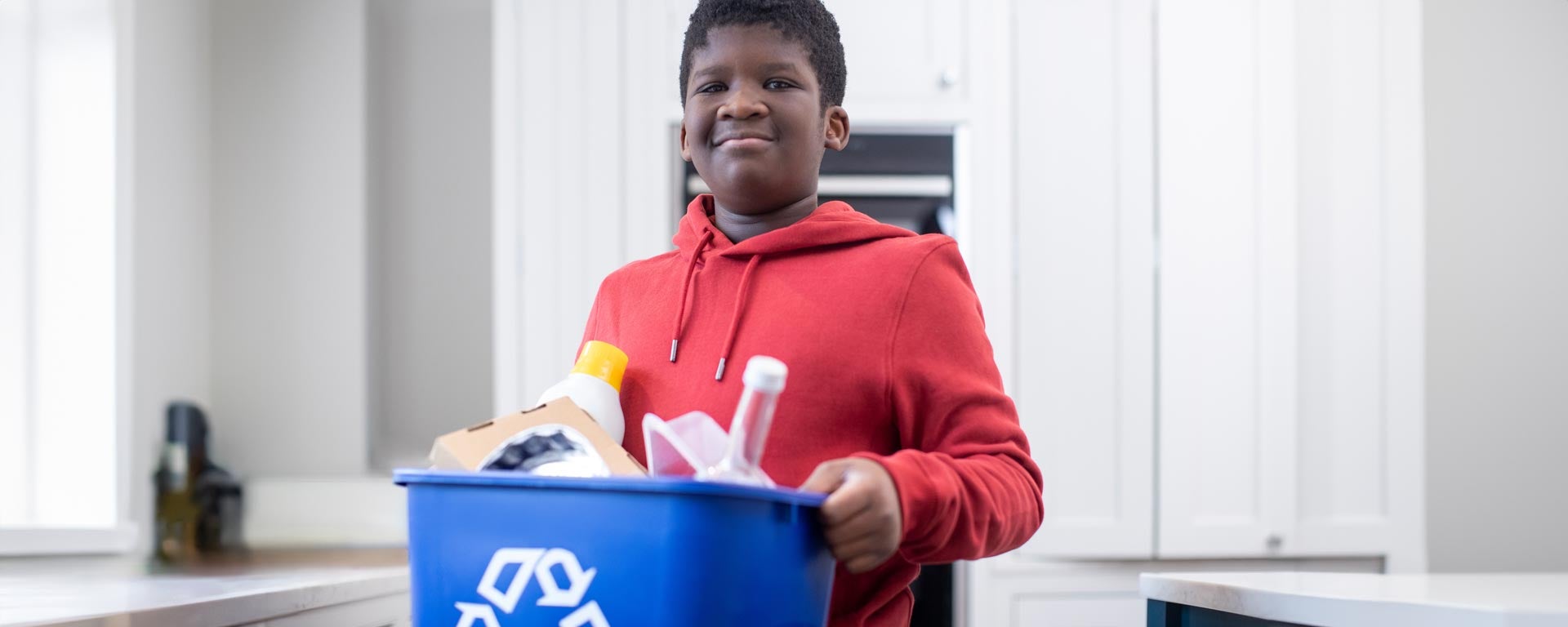 youth carrying recycling bin