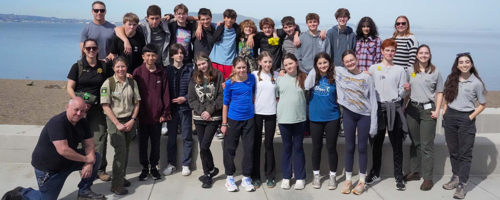 middle school class field trip group photo with Parks Rangers and Sustainability Department staff in front of San Francisco Bay